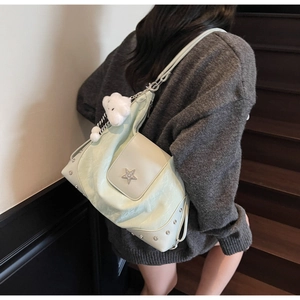 Détail du sac plissé vert menthe avec emblème d'étoile, rivets et charm nuage