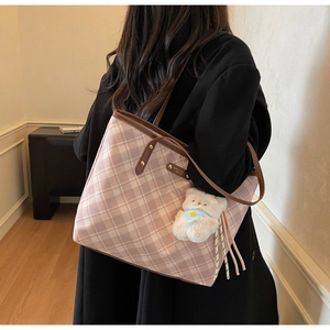 Détail du sac cabas à carreaux roses et blancs avec bordure en cuir marron et breloque ours