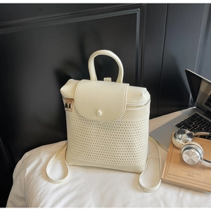 Detail of cream straw woven backpack with leather flap and premium golden metal zippers