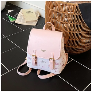 Nahaufnahme des rosa geblümten Vintage-Rucksacks mit Cartoon-Hundemustern auf schwarzer Fliese