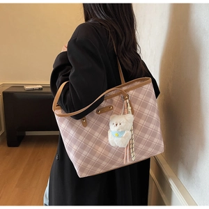 Détail du grand sac cabas à carreaux roses avec anses en cuir et porte-clés ours