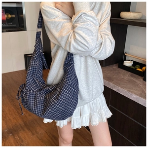 Detailed close-up of blue and white checkered half-moon bag with drawstring detail