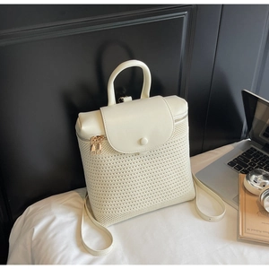 Detailed close-up of woven mesh pattern and cream leather trim on the backpack