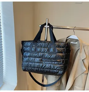 Détail du sac cabas matelassé noir brillant avec une poche latérale zippée