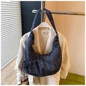 Detail view of navy blue checkered fabric on minimalist crescent shoulder bag for women