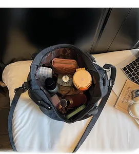 Vue de l'intérieur spacieux du cabas en toile grise montrant les objets du quotidien