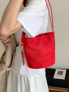 Minimalist bright red matte leather bucket bag with slim shoulder strap for women