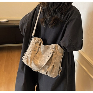 Gros plan du sac cabas vintage en cuir kaki avec clous argentés et détails anneaux