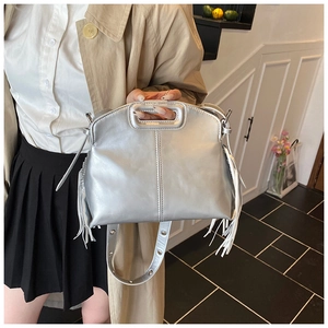 Detail of silver metallic tote bag with hollow rectangular handle and tassel fringe decoration