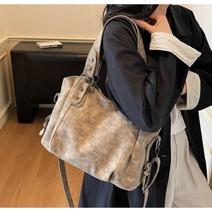 Détail du sac cabas gris vintage avec rivets métalliques et texture de cuir souple