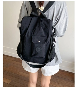 Rear view of a model wearing a black multifunctional nylon backpack with large capacity