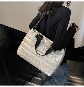 Détail du sac fourre-tout matelassé blanc en nylon avec bandoulière en toile noire