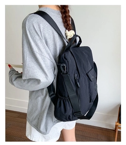 Lifestyle shot of a black nylon backpack for women with spacious pockets and straps