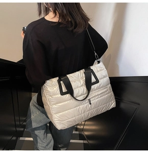 Sac cabas matelassé blanc crème avec bandoulières noires porté par un mannequin stylé