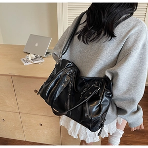 Detail shot of the black PU leather tote with metal zippers and pleated texture