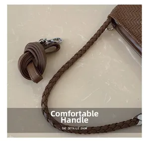 Detail of brown woven leather bag featuring the comfort handle and silver hardware