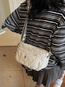 Cream nylon crossbody bag with multi-zip pockets and stylish wide patterned strap