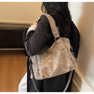 Détail du sac cabas vintage en cuir mat avec anneau en métal et bandoulière large