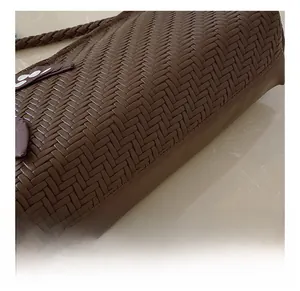 Close-up of premium dark brown woven texture on an elegant leather shoulder bag