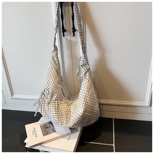Detail view of black and white checkered canvas hobo bag with adjustable buckle strap
