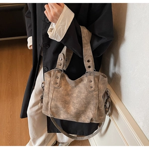 Vue détaillée du sac cabas kaki vintage avec rivets métalliques et bandoulière