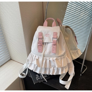 Detail eines weißen Polka-Dot-Rucksacks mit rosa Rüschensaum und dekorativen Lederriemen
