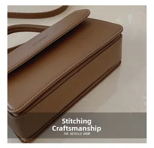 Detail showing high-quality stitching and matte brown leather texture on the handbag
