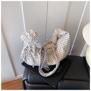 Detail of grid pattern fabric and adjustable drawstring on large commuter dumpling bag