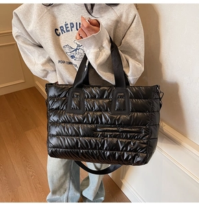 Détail du sac cabas matelassé noir avec larges anses et poche extérieure zippée