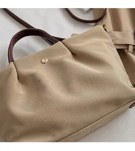 Détail du sac plissé en toile kaki avec anse en cuir et boucle en métal doré