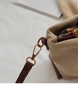 Détail de la quincaillerie en cuivre vintage et bandoulière en cuir marron sur sac canevas