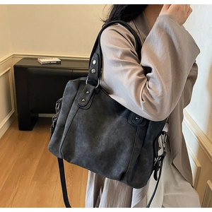 Vue détaillée du sac cabas en cuir gris foncé rétro avec rivets métalliques et ferrures