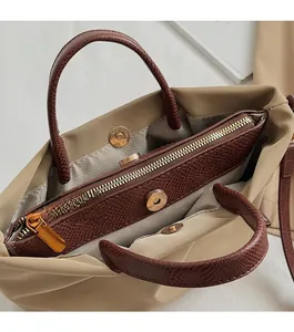 Détail de la fermeture magnétique et compartiment zippé doré du sac en toile souple
