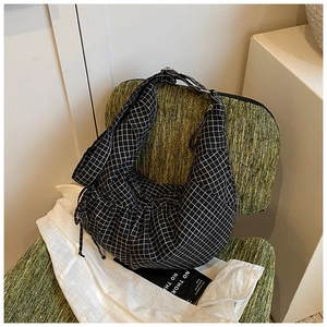 Detail showing checkered black and white hobo bag with adjustable silver buckle