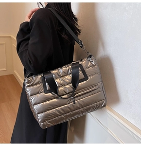 Vue détaillée du sac cabas matelassé argenté porté en bandoulière avec sangle noire