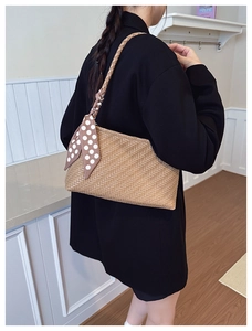 Detail view of woven shoulder bag with polka dot scarf on model back perspective