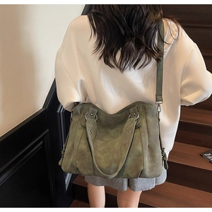 Détail du grand sac cabas vert foncé avec texture vintage et bandoulière sur le mannequin