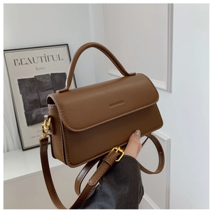 Close-up of brown leather handbag with MULANKOU logo and gold metal buckle detail