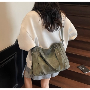 Détail d'un sac cabas vert olive foncé avec œillets métalliques et bandoulière réglable