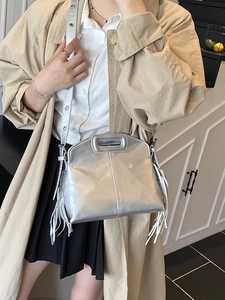 Silver metallic fringe tote bag with hollow handle shown on a stylish model