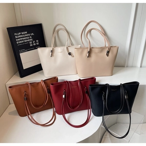 Close-up of textured PU leather tote bags in five colors with metallic buckle details