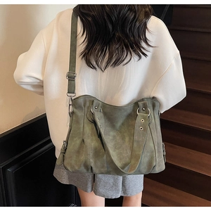 Détail du grand sac hobo en daim vert olive montrant la texture plissée et souple