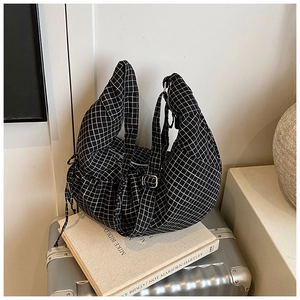 Detail view of black and white vichy check tote bag with drawstring and metal buckle strap