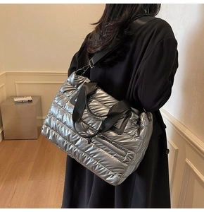 Vue détaillée d'un sac cabas matelassé argenté porté par un mannequin en studio
