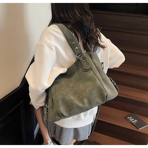 Détail d'un grand sac cabas vert foncé porté avec une tenue d'automne décontractée