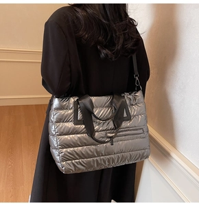 Détail du sac fourre-tout argenté matelassé avec sangles noires et fini métallique