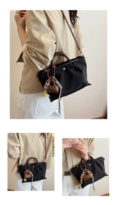 Détail du sac à main en nylon noir avec breloque cœur en cuir brun et corde tressée