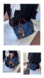 Détails du sac cabas bleu marine en nylon avec poignées en cuir et breloque smiley jaune