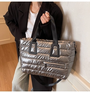 Détail du sac cabas matelassé argenté avec bandoulière noire et finition métallique
