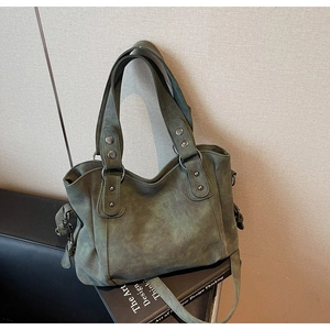 Détail d'un grand sac fourre-tout vert vintage avec rivets et bandoulière réglable